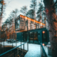 cabin made of three shipping containers stacked on each other in woods in winter