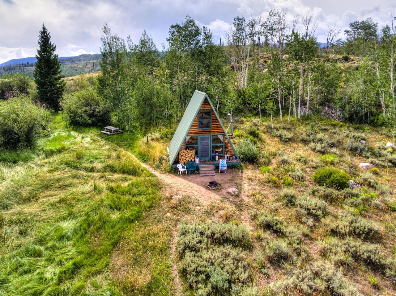 wooden a-frame surrounded by greenery filled landscape cabins in the USA