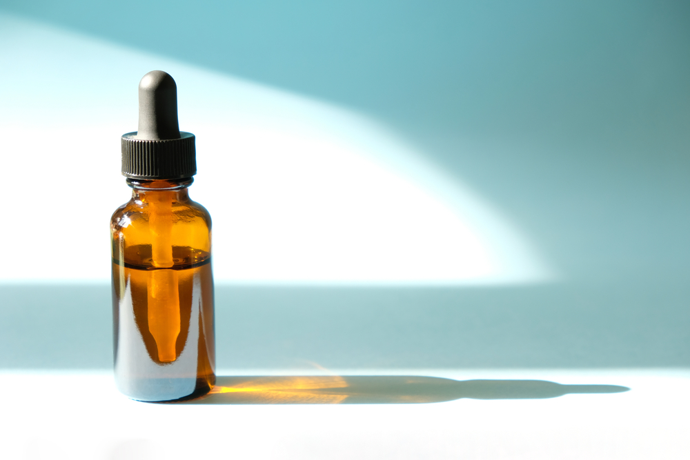 A bottle of essential oil on a blue background