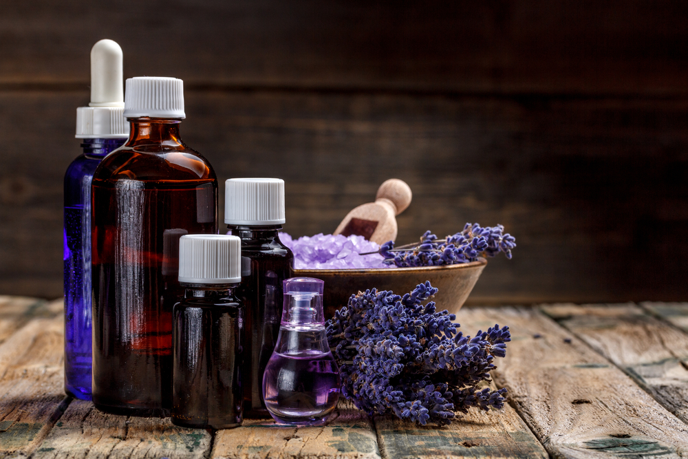 Essential oils on a wood top with lavender