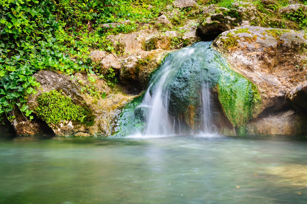The Hot Springs National Park features warm waters and slight falls in the middle of mountains! 