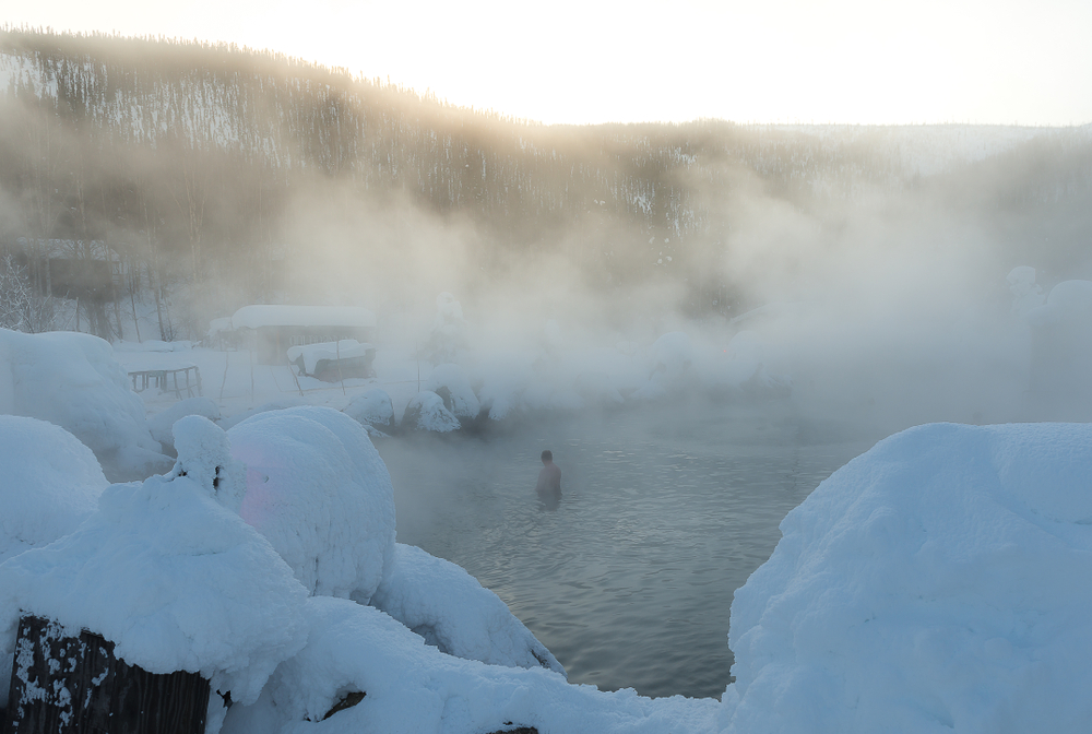 Smoke rises from the hot springs in the winter of Alaska. 