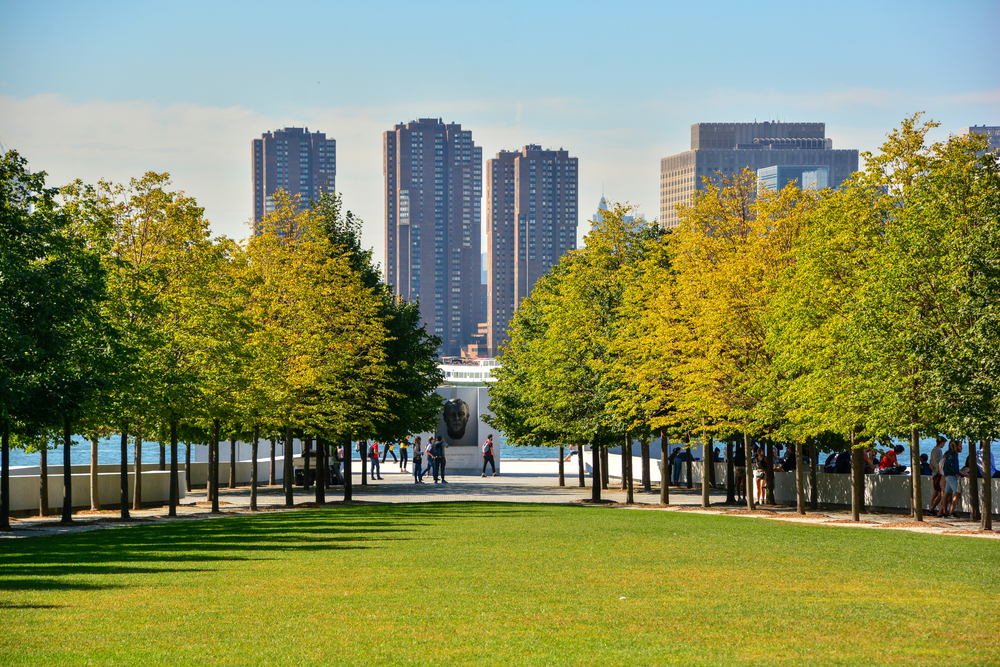 The view down Four Freedoms Park lane of trees with Manhattan in the background, one of the most unusual things to do in New York