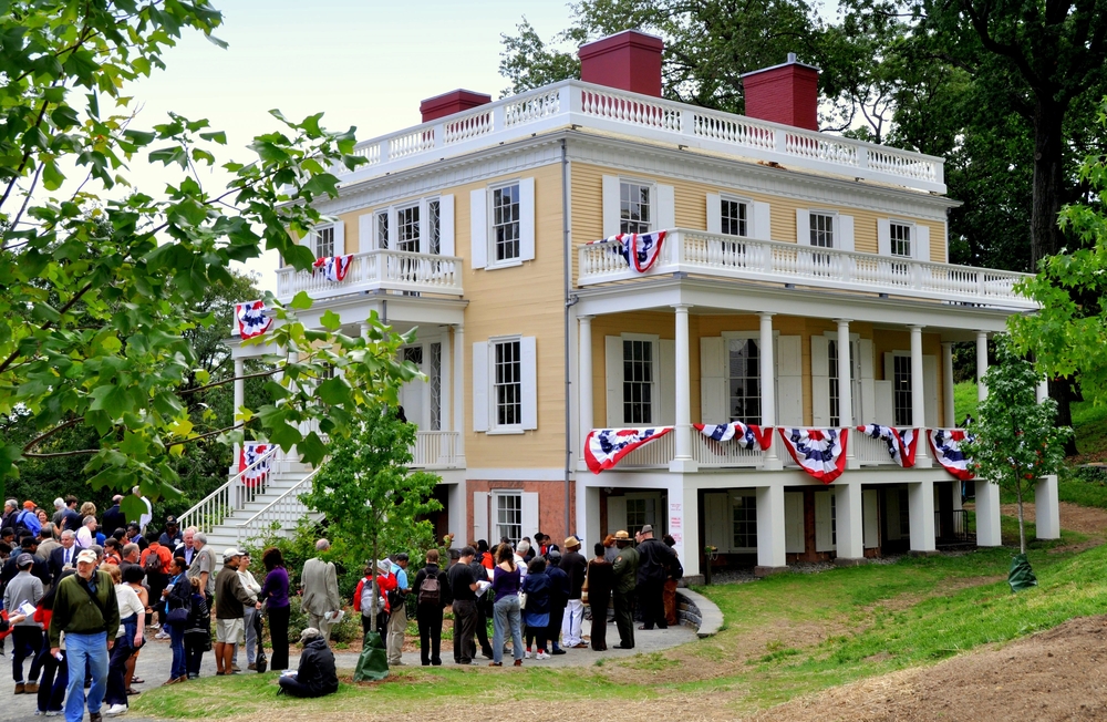 A group of people standing outside of Hamilton Grange, one of the most unusual things to do in New York