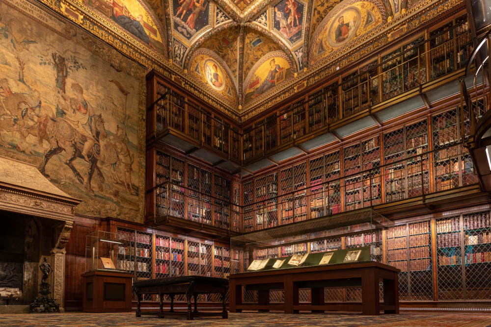 A room full of rare manuscripts with a large fireplace and tapestry at the Pierpont Morgan Library, one of the most unusual things to do in New York