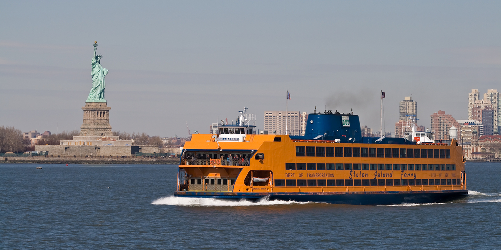 The Staten Island Ferry crossing the river with the Statue of Liberty in the background,
