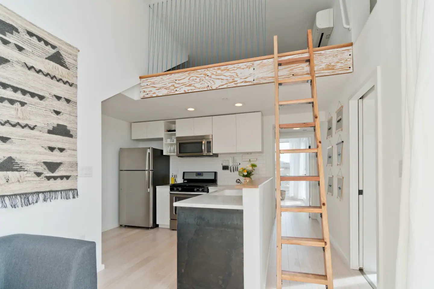 Sleek, modern beach home in San Diego, one of the best California Airbnbs! A look at the kitchen and loft, with a ladder going up to the loft.