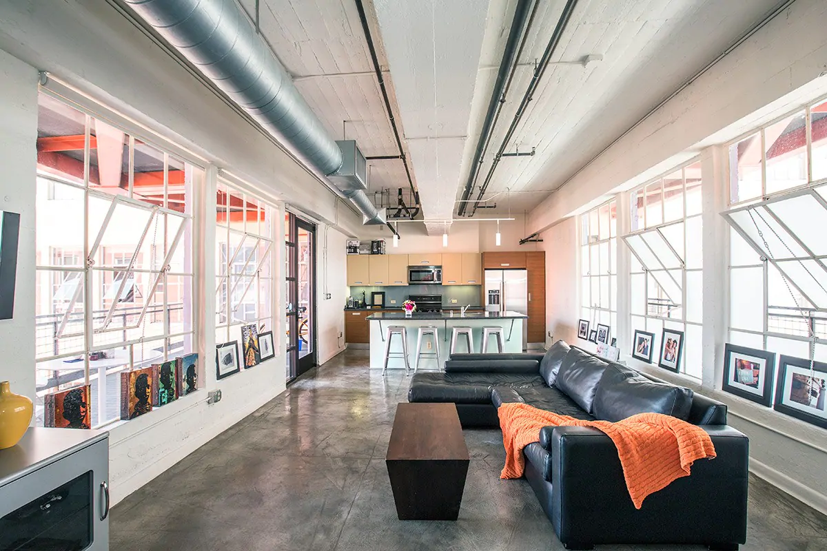 Industrial Loft in downtown Los Angeles, with cool hinged windows, natural light, concrete floors, and metallic and orange decor.  One of the best Airbnbs in California.