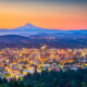 Portland city skyline at sunset with Mt. Hood visible in the distance.