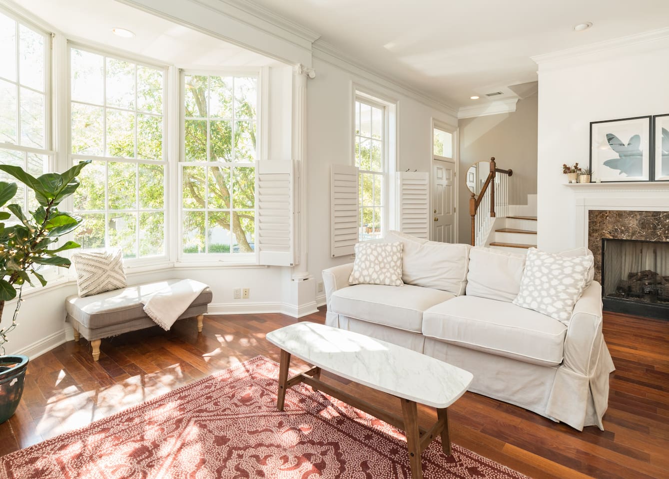 View of the clean white living room and lots of natural light in the Pretty Home one of the best Airbnbs in Savannah