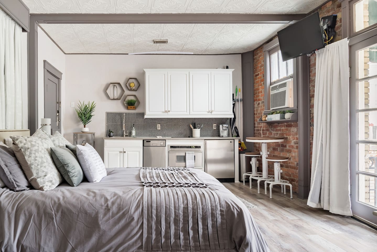 Clean grey and white exterior with exposed brick walls at the Urban Chic Studio with Balcony in Savannah Georgia