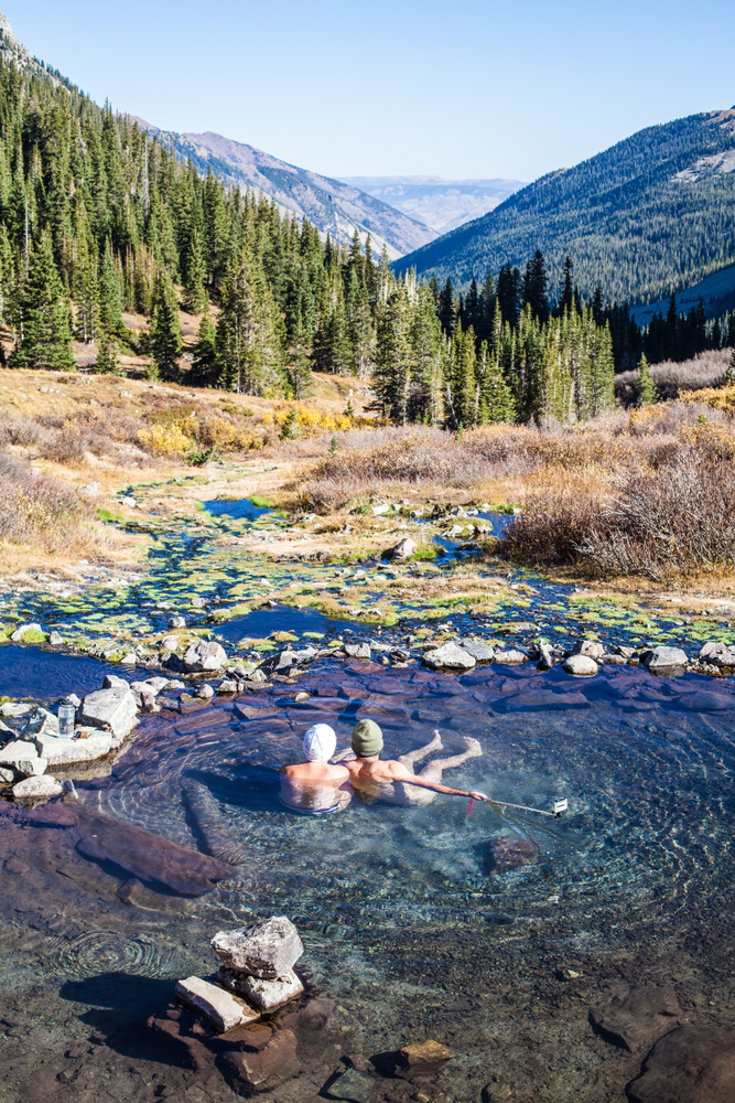 Photo of a couple enjoying mountain views from a hot springs in Colorado