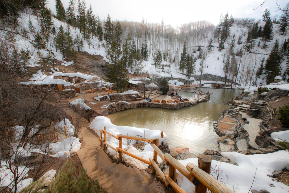 A photo of Strawberry Park Hot springs, a natural hot springs in Colorado, covered in snow. 