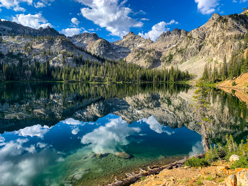 Crystal blue lake surrounded by mountains and pine trees