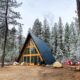 a frame cabin surrounded by tall pines dusted in snow one of the most cozy cabins in Idaho