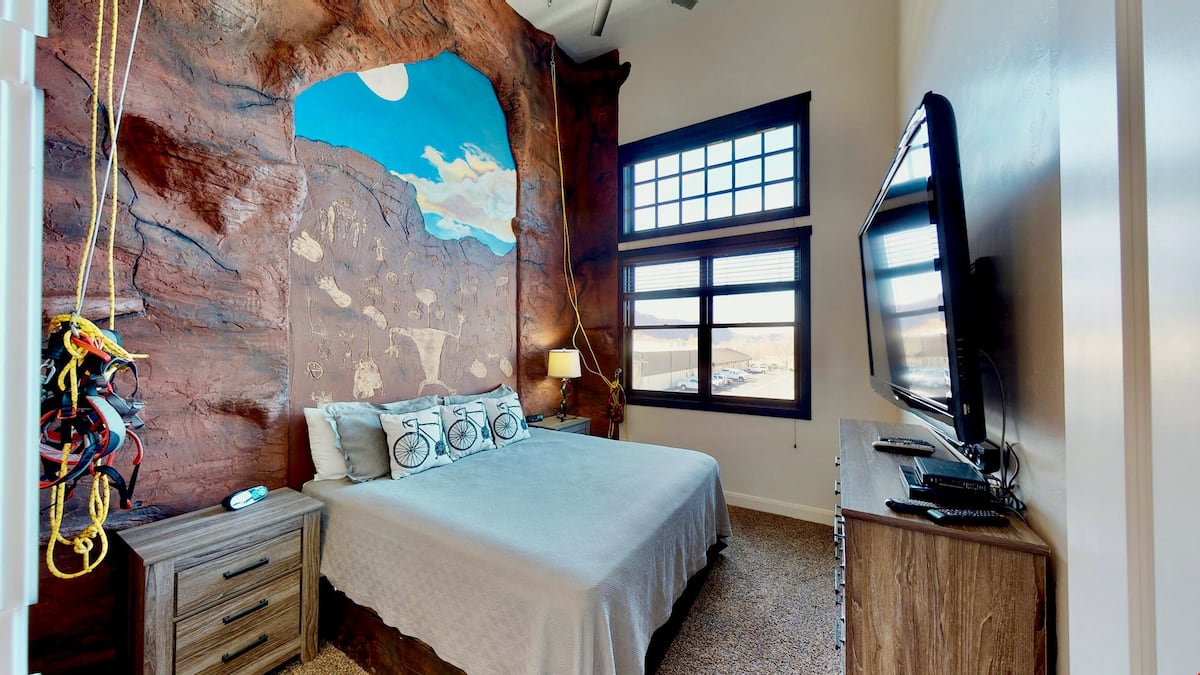 Master bedroom with a rock wall