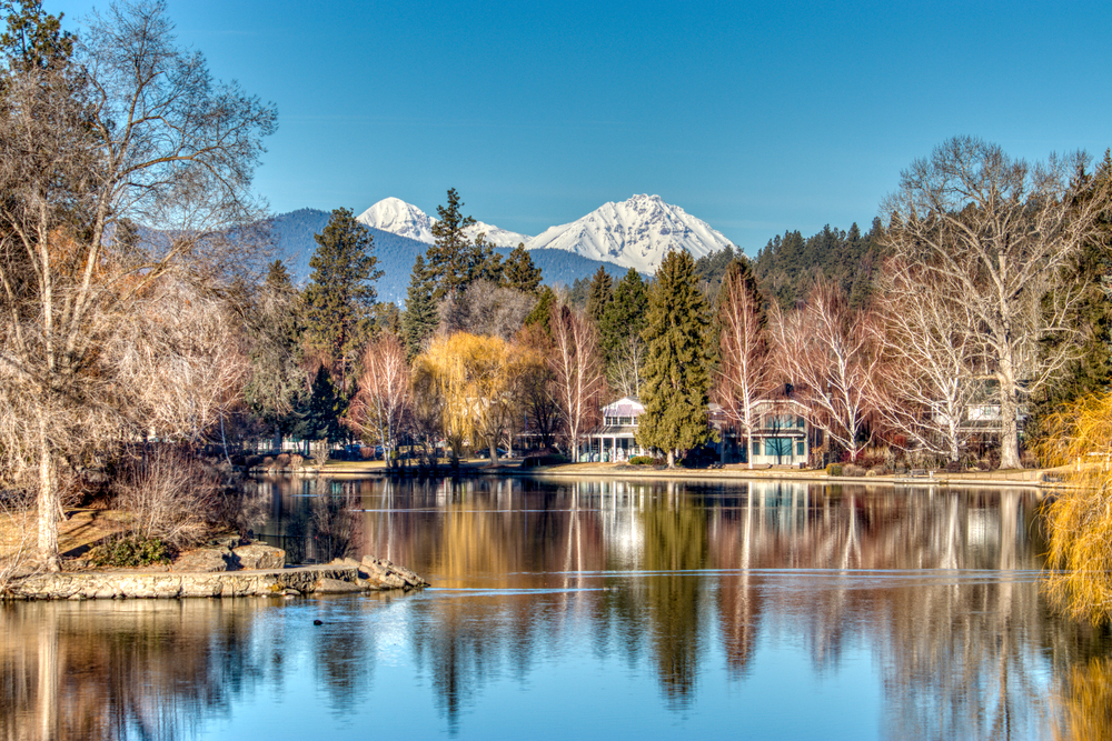 View of houses along the water with Mt. Rainier in the distance in Bend Oregon, one of the cutest small towns on the West Coast