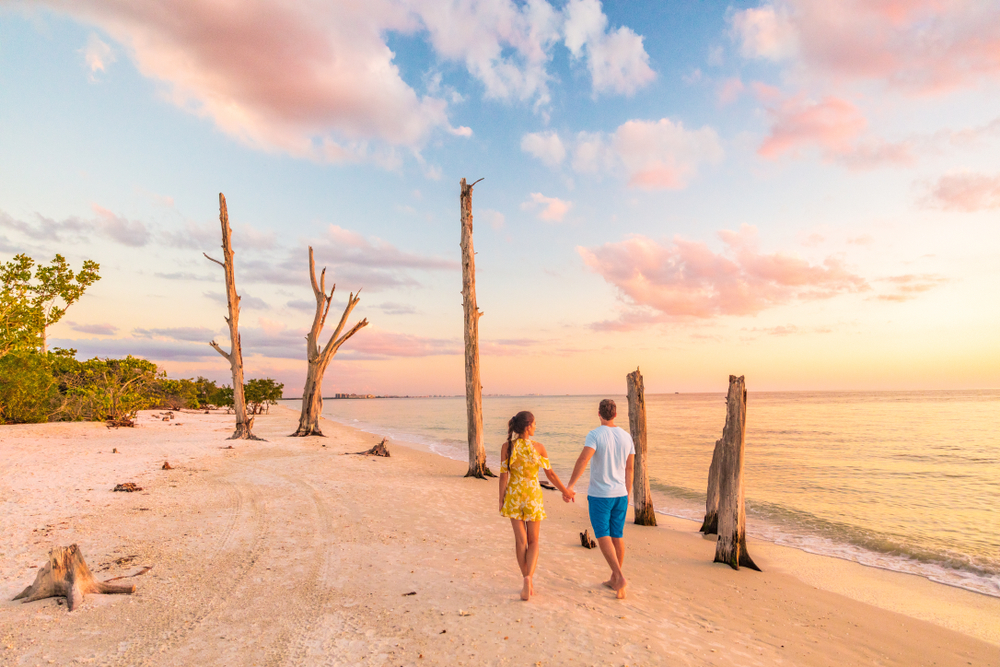 Couple walking on a beach in Florida as the sun sets