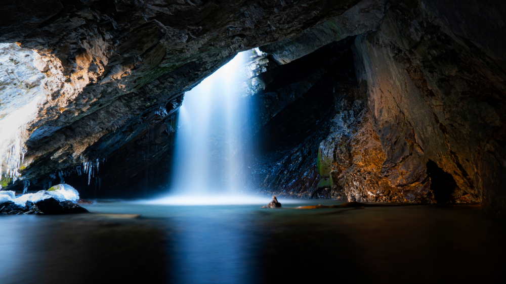 Looking at the Donut Falls as it drops into a cavern with a pool of water at the bottom