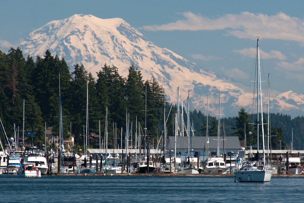 Sailing boats in Gig Harbor in the Puget Sound with mountain range in the distance