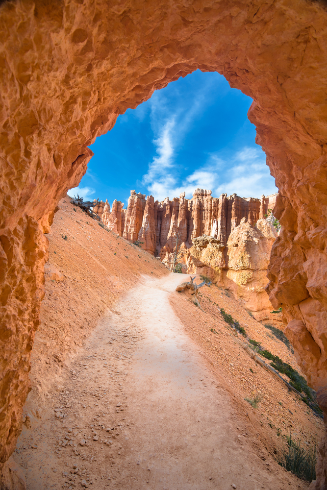 Looking through one of the arches on the Navajo Loop onto the trail with rock formations in the background