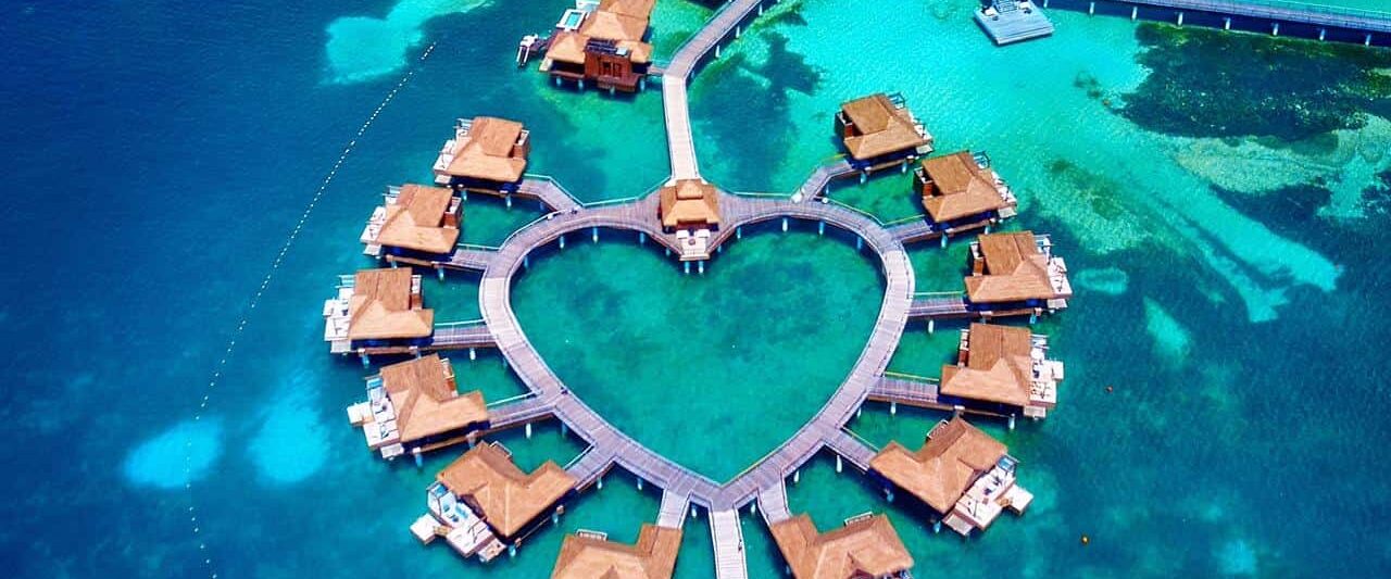 Arial shot of overwater bungalows near the usa in the shape of a heart