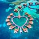 Arial shot of overwater bungalows near the usa in the shape of a heart