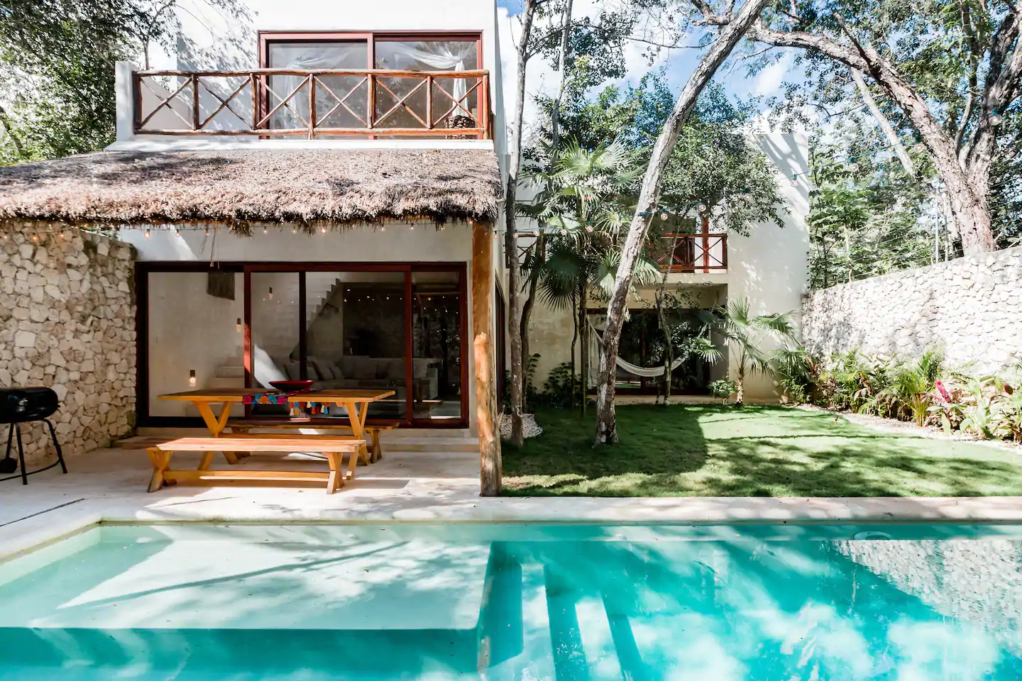 This is one of the best Airbnbs resorts in Tulum. The pool looks so clean and there is a picnic table, BBQ, and hammock visible.