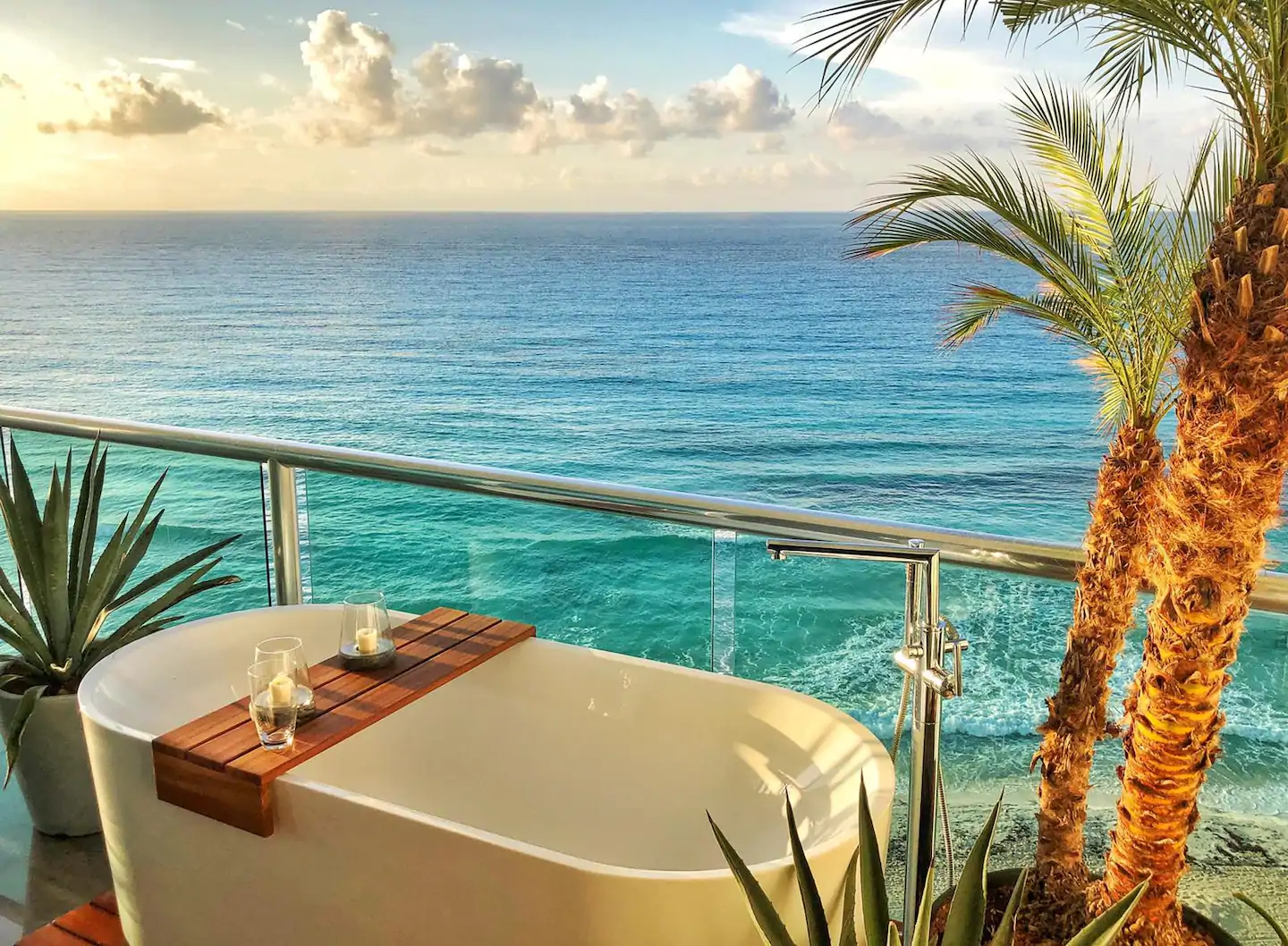 The view from an epic outdoor bathtub surrounded by plants with an ocean view The Quarry is one of the most luxurious Airbnbs in Cancun!