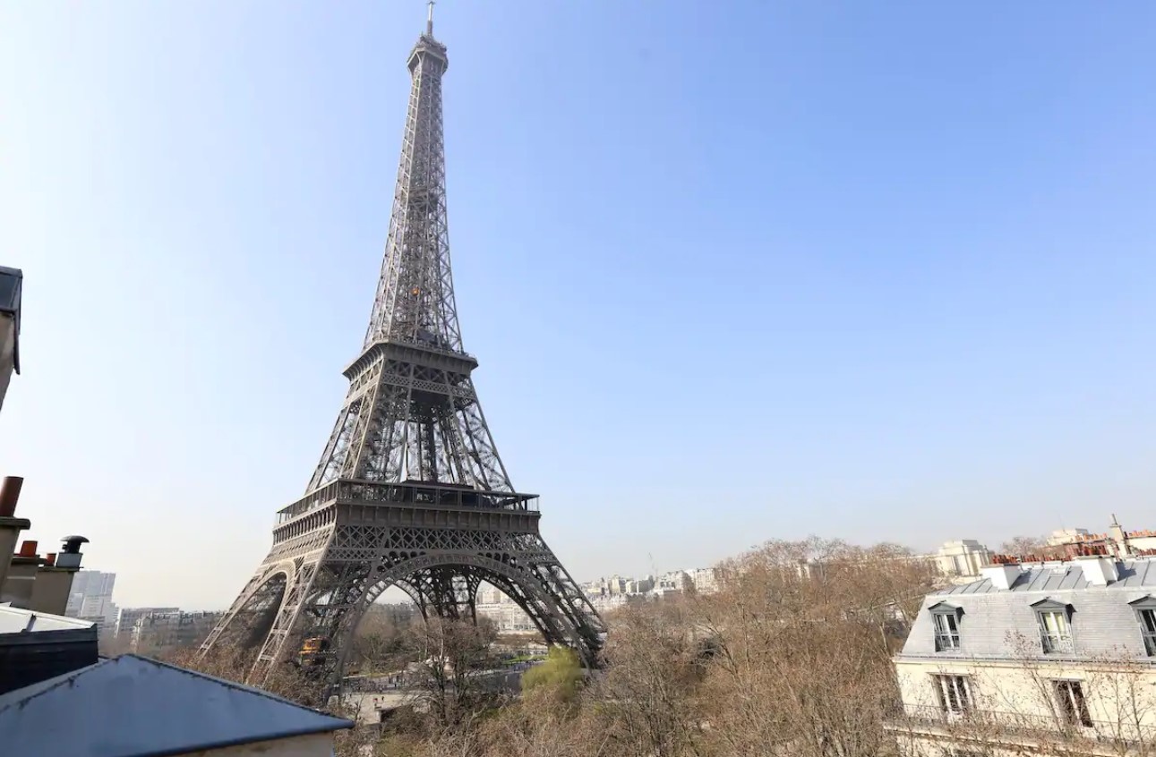 The view from the window of a small Parisian apartment of the Eiffel Tower and other older buildings