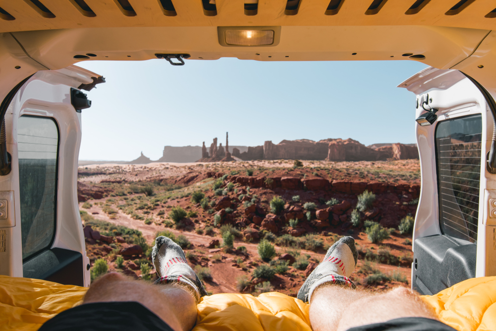 photo of a desert view from the back of a van showcasing socks, one of the important car camping essentials