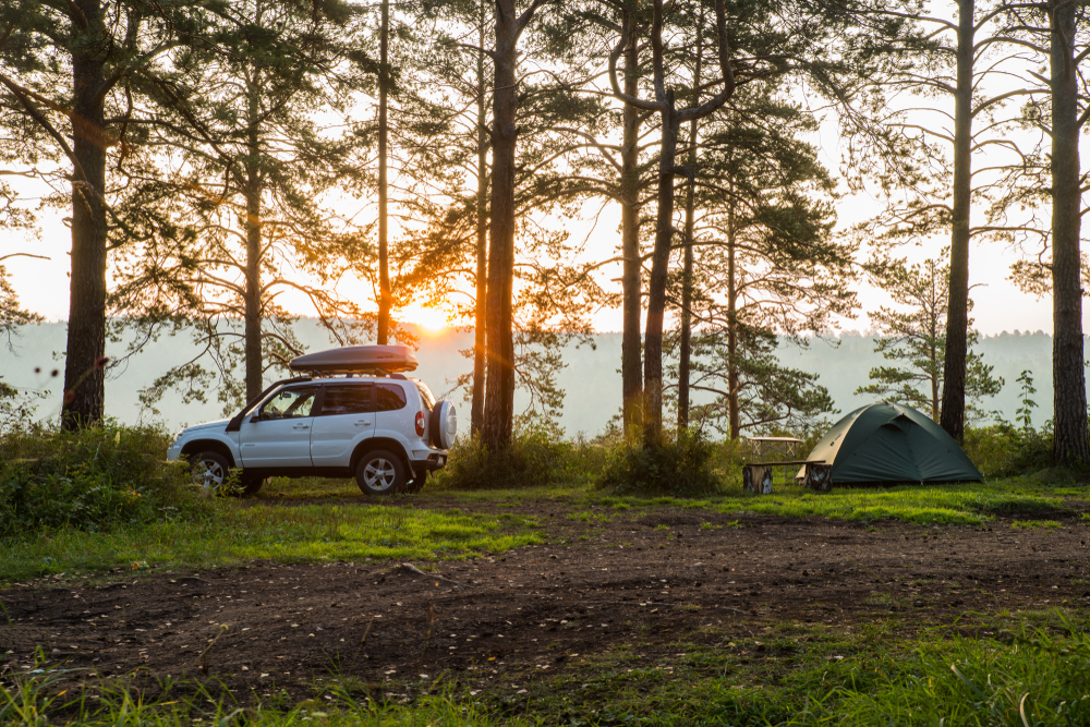 photo of a car and tent at sunset 