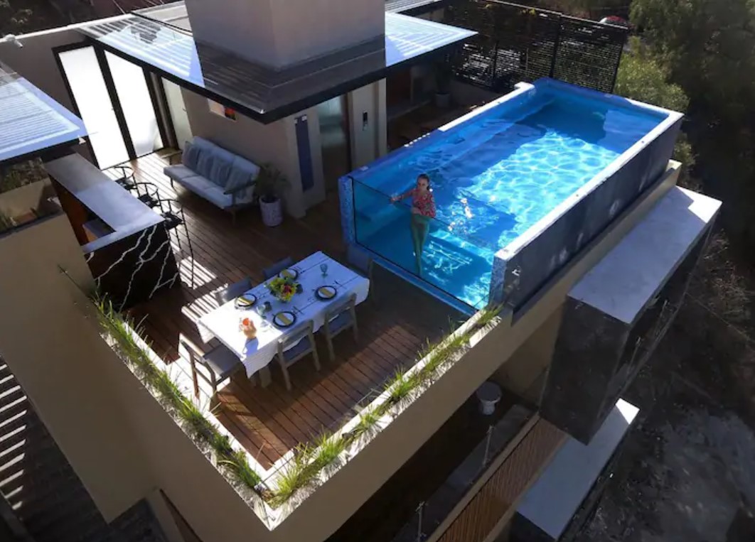 An aerial view of a rooftop infinity pool and common area airbnbs in mexico