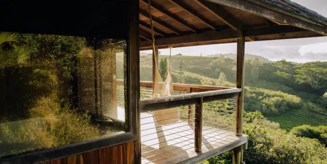 a treehouse in the hills of Hawaii with a hammock on a lanai