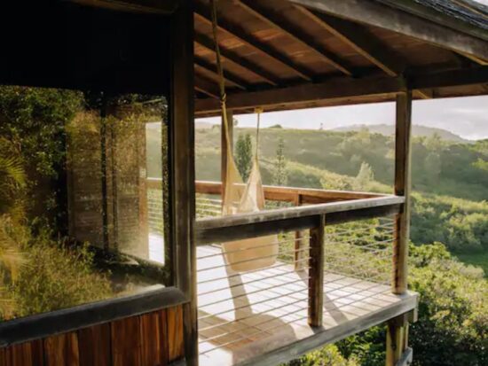 a treehouse in the hills of Hawaii with a hammock on a lanai