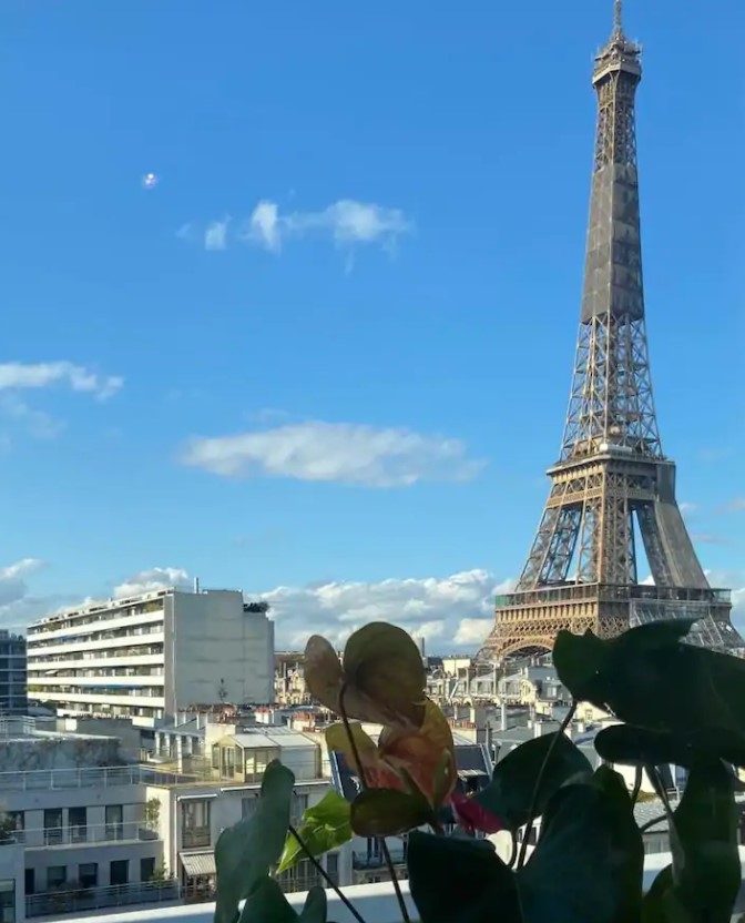 The view of the Eiffel Tower on a sunny day with blue skies from a small balcony