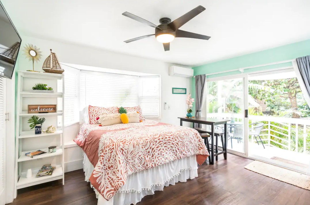 The inside of a studio apartment in Hau'ula Hawaii with a queen sized bed and large sliding doors that lead to a private lanai airbnbs in hawaii
