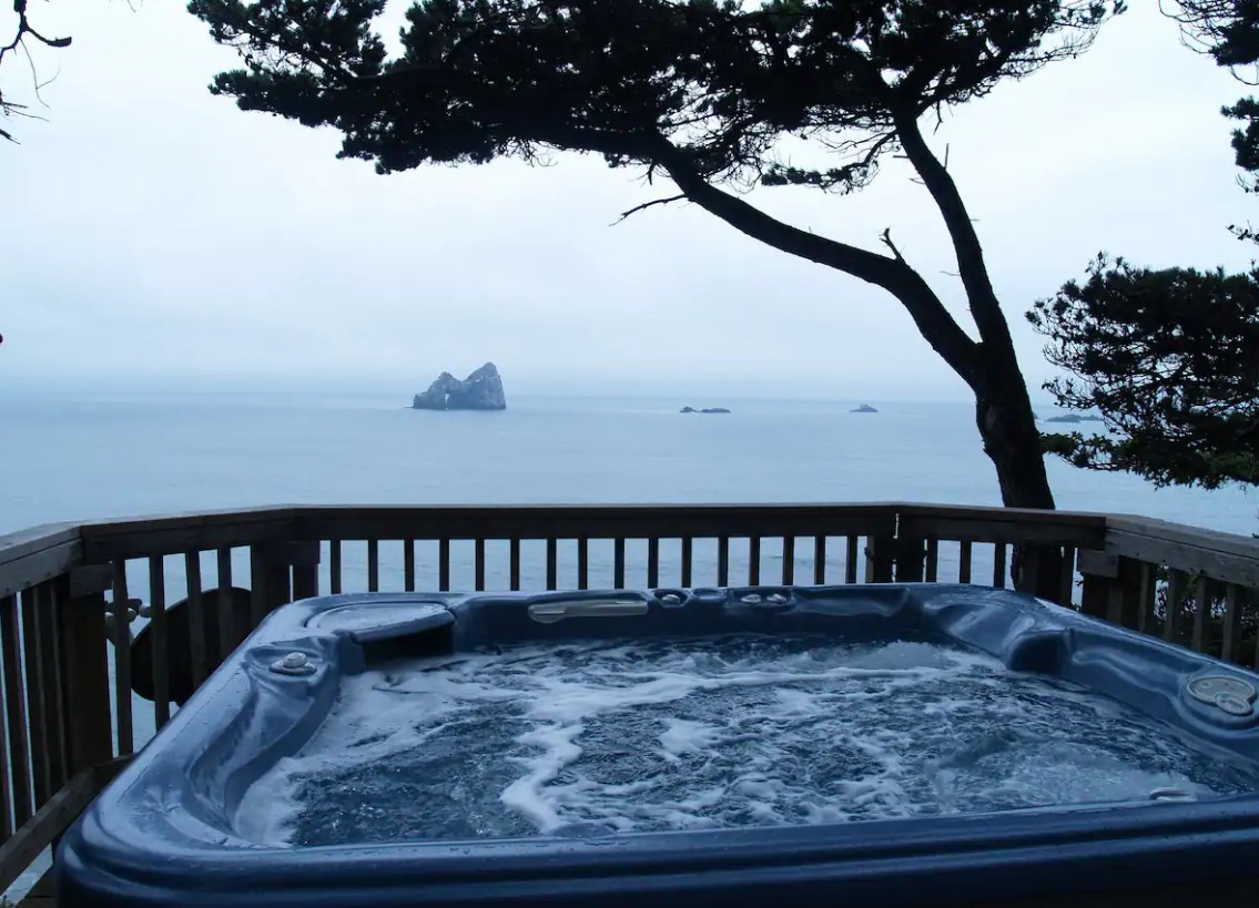 A private hot tub that looks out at a private beach and cove on the Oregon Coast