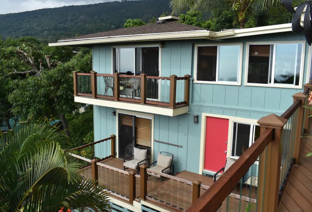 The exterior of a home on the side of a hill in the tropical rainforest of the Big Island in Hawaii with two large lanais