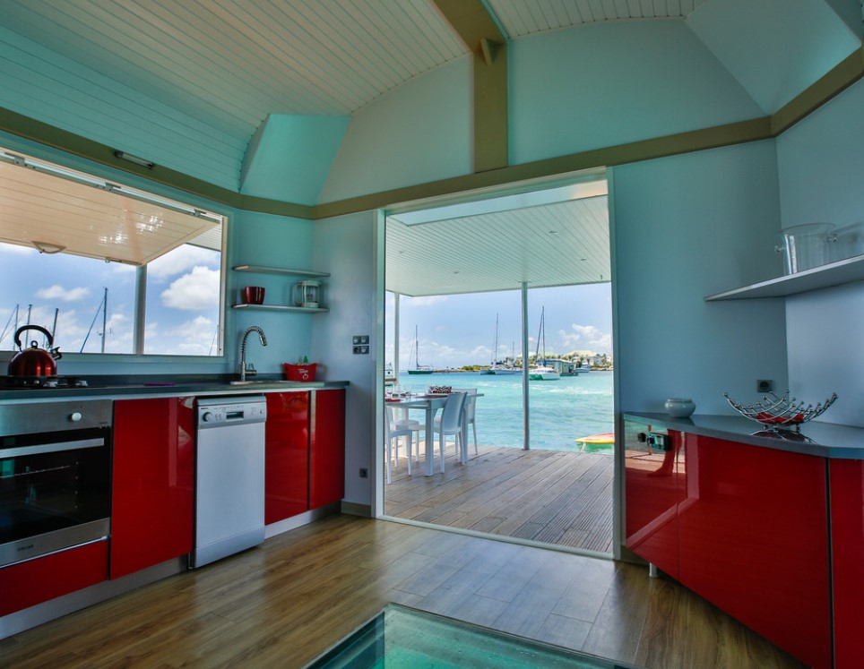 An open air kitchen with a glass floor in on an overwater bungalow in the Caribbean