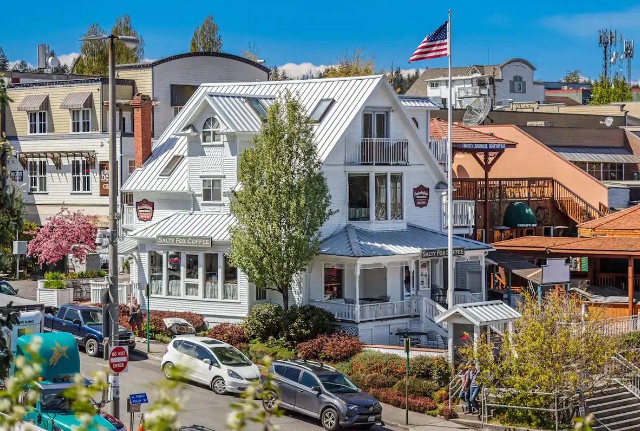 A large white Victorian house in the middle of a cute city on San Juan Island in Washington