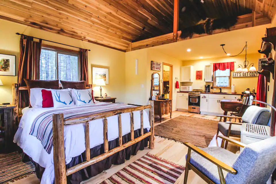 Interior shot showing the luxurious bed and modern kitchen of this cozy one room log cabin.  This is is one of the best cabins in Eastern Washington State. 