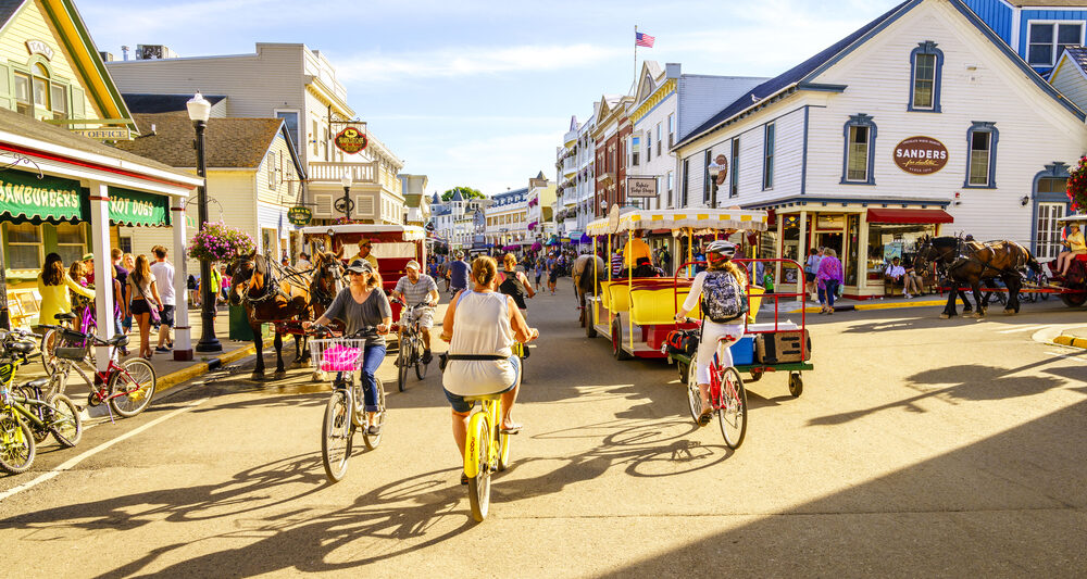 people biking on the streets of Mackinac Island one of the best small town beaches in the usa