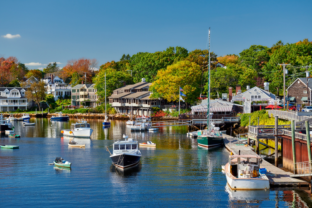 A marina surrounded by homes and trees and full of sail boats and yachts in Ogunquit Main best small beach towns in the usa