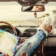 Girl with feet on dashboard of a car in an article about road trip questions