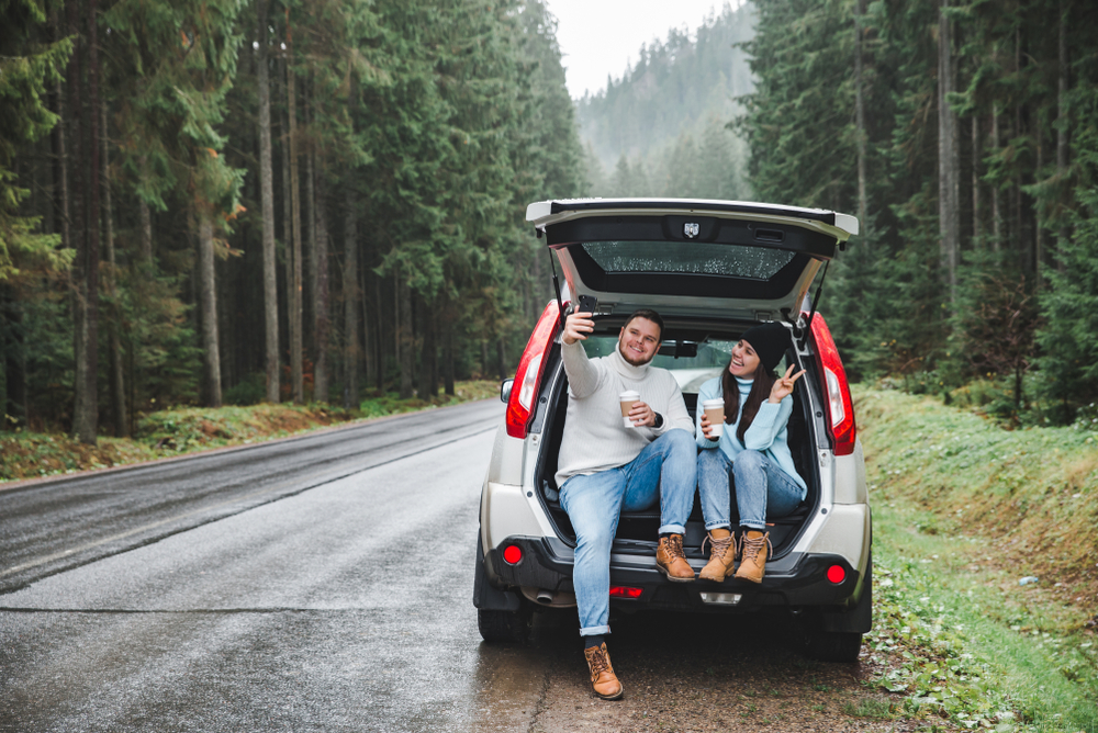 A couple in the back of a car in an article about road trip questions for couples