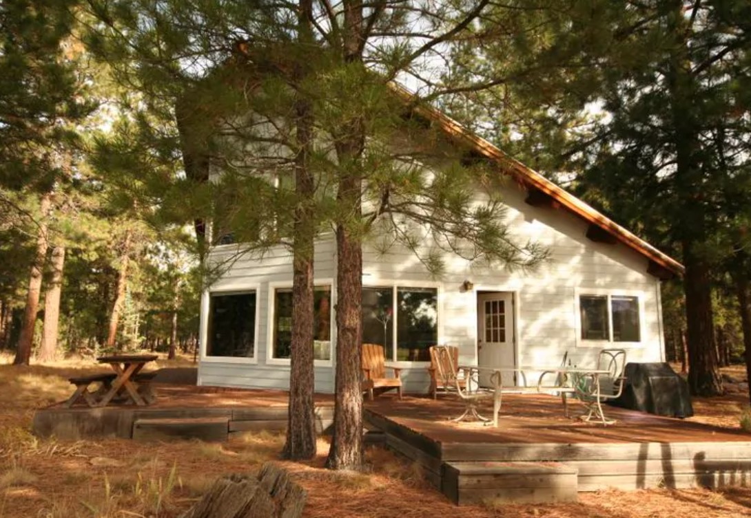 The exterior of a uniquely shaped cabin in the woods in Oregon