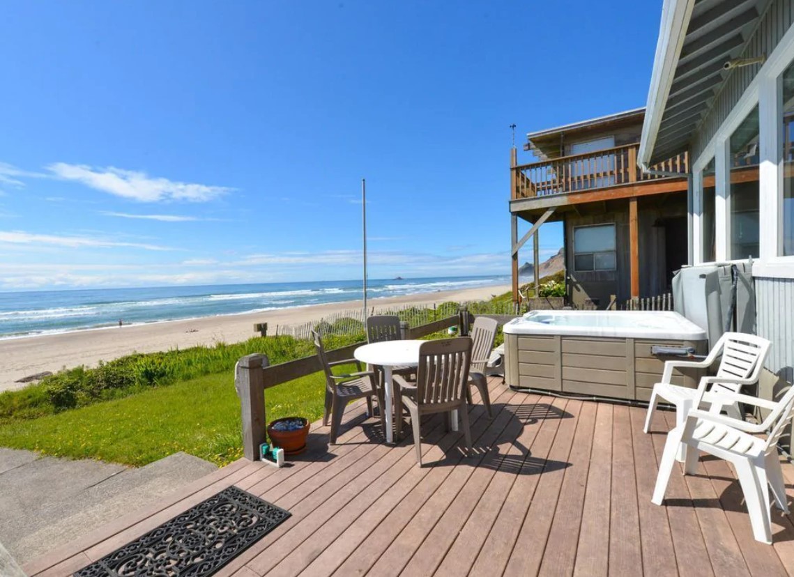 The view of the beach from the private deck at a VRBO in Oregon on a sunny day