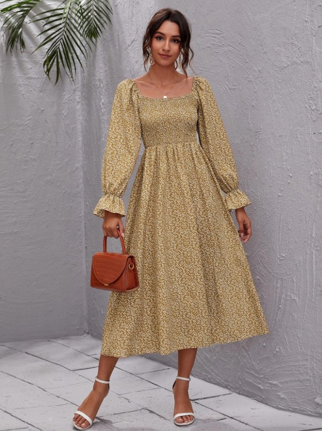 A woman in a long sleeved dark yello maxi floral cottagecore dress