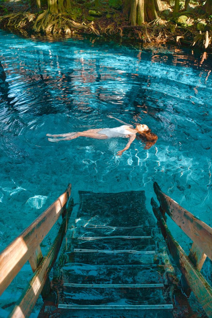 Girl swimming at Ginnie Springs, a great place to see on a Florida road trip or weekend getaway on the East Coast.